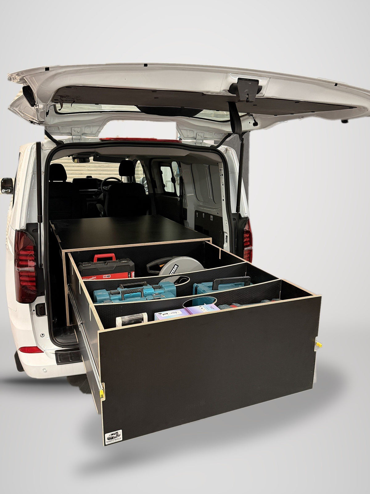 A SheffRack drawer at full extension from the back of a van, loaded with power tools